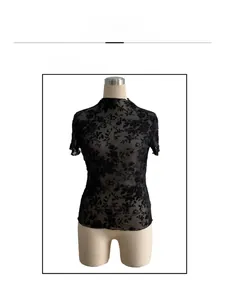 Detail of sheer black mesh short sleeve top with flocked rose patterns and ruffled collar