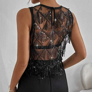 Détail du haut à paillettes noires avec motifs géométriques et maille transparente