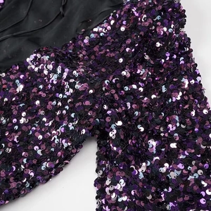 Détail macro de sequins dégradés violet et bleu sur le tissu d'une robe de soirée chic
