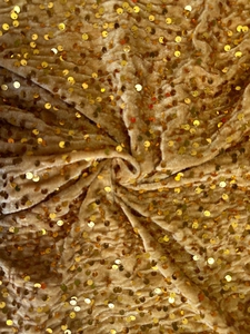 Detail of champagne gold sequin velvet fabric with elegant metallic shine and texture