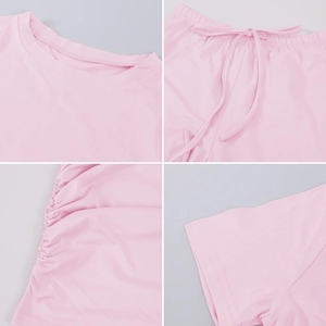 Detail of pink lounge set showing crew neck, drawstring waist, and pleated side seams
