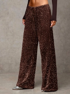 Close-up of sparkling chocolate brown sequin wide-leg trousers with drawstring waist detail