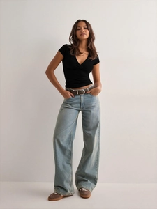 Detail of slim fit black wrap V-neck T-shirt with high waist jeans and vintage belt