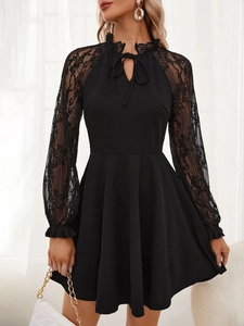 Detailed view of the elegant lace neckline and black long sleeves with a ribbon bow detail