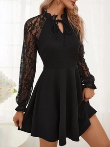 Detailed view of elegant floral lace sleeves and tie-up neckline on a black A-line dress