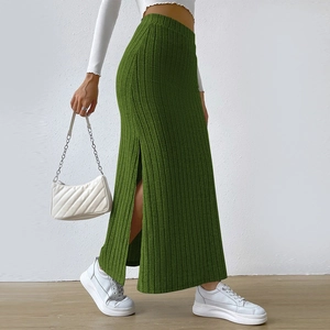 Macro detail of dark green high-waisted ribbed knit skirt featuring a stylish side slit