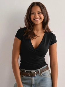 Detail of a slim fit black V-neck wrap short sleeve T-shirt styled with denim jeans