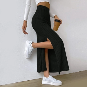 Detail view of the side slit on a black high-waisted ribbed knit maxi skirt