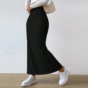 Detail of high waisted black ribbed knit maxi skirt with side slit and vertical texture