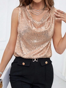 Detail of rose gold sequin cowl neck top paired with black trousers and gold belt buckles