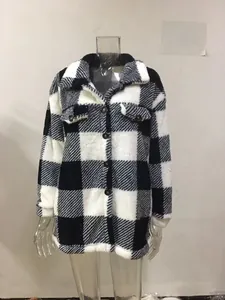 Detail der schwarz-weiß karierten Plüschjacke mit Taschen und Knopfleiste im Fokus