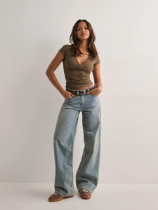 Slim fit brown V-neck wrap top styled with vintage high-waisted wide-leg blue jeans