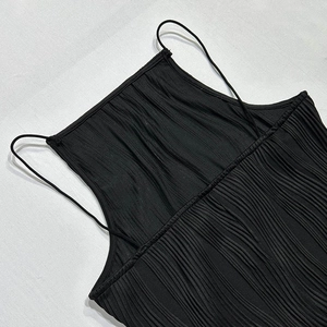 Detail of black spaghetti strap dress featuring premium pleated fabric texture and high neckline