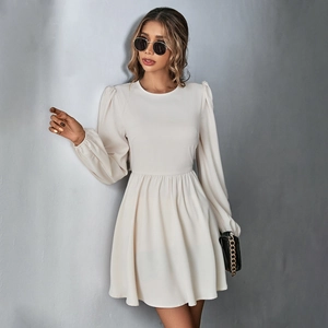 Detail of elegant cream A-line dress featuring puff sleeves and cinched waist design