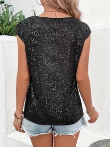 Dettaglio del top senza maniche con paillettes nere abbinato a pantaloncini in jeans sul retro