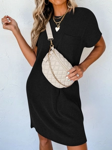 Détail de robe noire en maille côtelée avec poche poitrine et sac à bandoulière matelassé