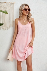 Détail du tissu d'une robe d'été rose avec broderie géométrique et fines bretelles roses
