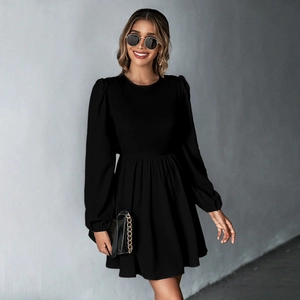 Detail of elegant black puff sleeve dress showing fitted waist and pleated A-line skirt