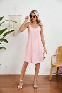 Détail d'une robe rose sans manches avec broderie anglaise délicate et fines bretelles