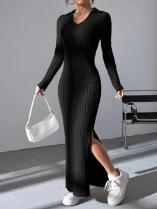 Detail view of the elegant black knit dress with a side slit and ribbed fabric texture