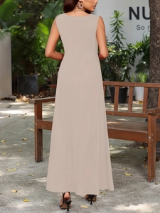 Outdoor view of beige sleeveless long dress showing the elegant back and flowing skirt