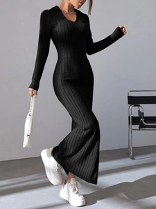 Detail of elegant black long-sleeve knit dress with ribbed texture and chic V-neck collar