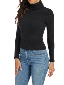 Close-up of black ribbed knit turtleneck showing vertical texture and premium stitching