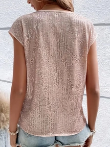 Dettaglio di paillettes oro rosa su un top ampio a girocollo con texture metallica lucida