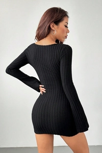 Detail shot of black bodycon knit dress featuring ribbed texture and slim fit sleeves