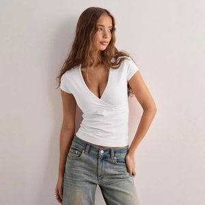 T-shirt blanc Y2K à col en V pour femme coupe ajustée avec un jean bleu clair délavé chic