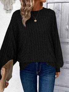 Detail of black ribbed knit sweater featuring a round neck and relaxed drop shoulders