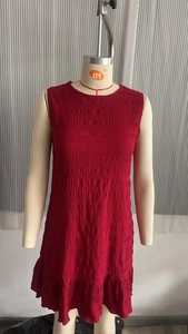 Détail de la robe sans manches rouge foncé avec tissu froncé et ourlet à volants