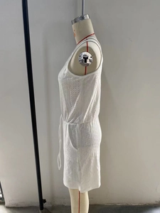 Detail of white hollow-out eyelet fabric romper with drawstring waist and pockets