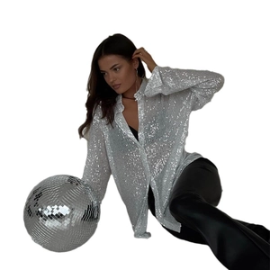 Gros plan sur les paillettes argentées et le col classique d'une chemise de fête
