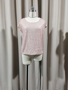 Dettaglio del top rosa con paillettes, perline a strisce verticali e girocollo a costine