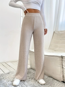 Women's high waist wide leg pants in beige ribbed knit fabric shown in a stylish room