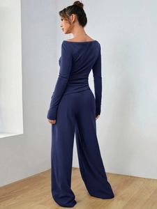 Dettaglio del top a maniche lunghe blu navy e dei pantaloni larghi in maglia pregiata