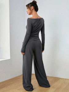 Vista laterale del set grigio da donna con top a barchetta e pantaloni larghi