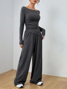 Vista dettagliata dell'elegante arricciatura laterale su questo top in maglia grigio scuro