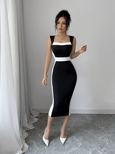 Détail de robe midi noire ajustée avec bandes blanches latérales et taille contrastée