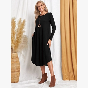Detail shot of black long sleeve dress featuring side pockets and a curved hem design