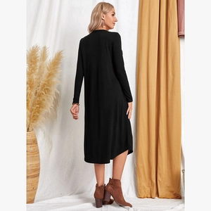 Rear view of a black knitted midi cardigan featuring a loose fit and curved hem design