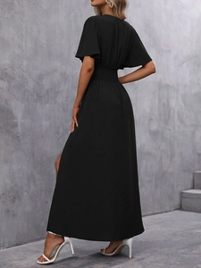 Vue latérale de robe longue noire à manches volantées, taille élastique et fente haute