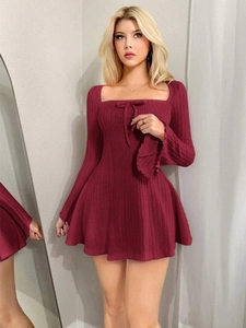 Detail des burgunderroten Strickkleids mit eckigem Ausschnitt und zierlicher Schleife