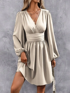 Detail of the elegant V-neck and lantern sleeves on a champagne beige mini dress