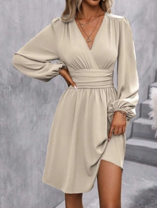 Detail of V-neckline and pleated waist on this beige long-sleeve dress for women
