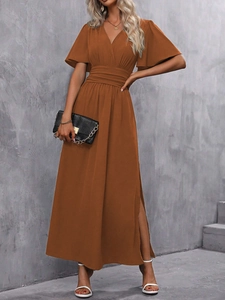 Détail d'une robe longue rouille avec décolleté en V, taille froncée et manches papillon