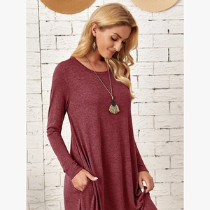 Close-up of the burgundy knit dress showing curved hem, side pockets, and soft texture