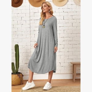 Detailed close-up of grey long sleeve dress with curved hem and knit fabric texture