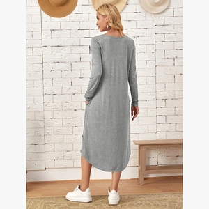 Detail view of the curved hem and side pockets on a grey long sleeve knitted dress